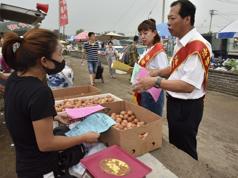 1錦州市委政法委政治部主任、市掃黑辦宣傳組組長(zhǎng)李偉(右一)走進(jìn)集市進(jìn)行普法宣傳