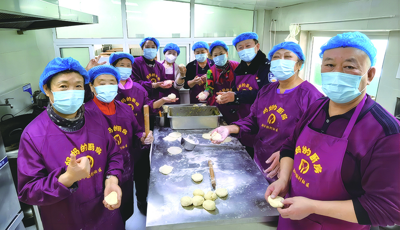 “媽媽廚房”志愿者們?cè)诤髲N包包子場(chǎng)景